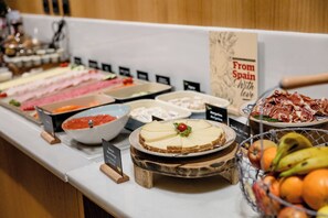 A buffet with various food items including meats, cheeses, and fruits. - Motel One Madrid-Plaza de España (Madrid)