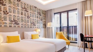 A hotel room with two beds, a balcony, and a dining area. - Motel One Madrid-Plaza de España (Madrid)