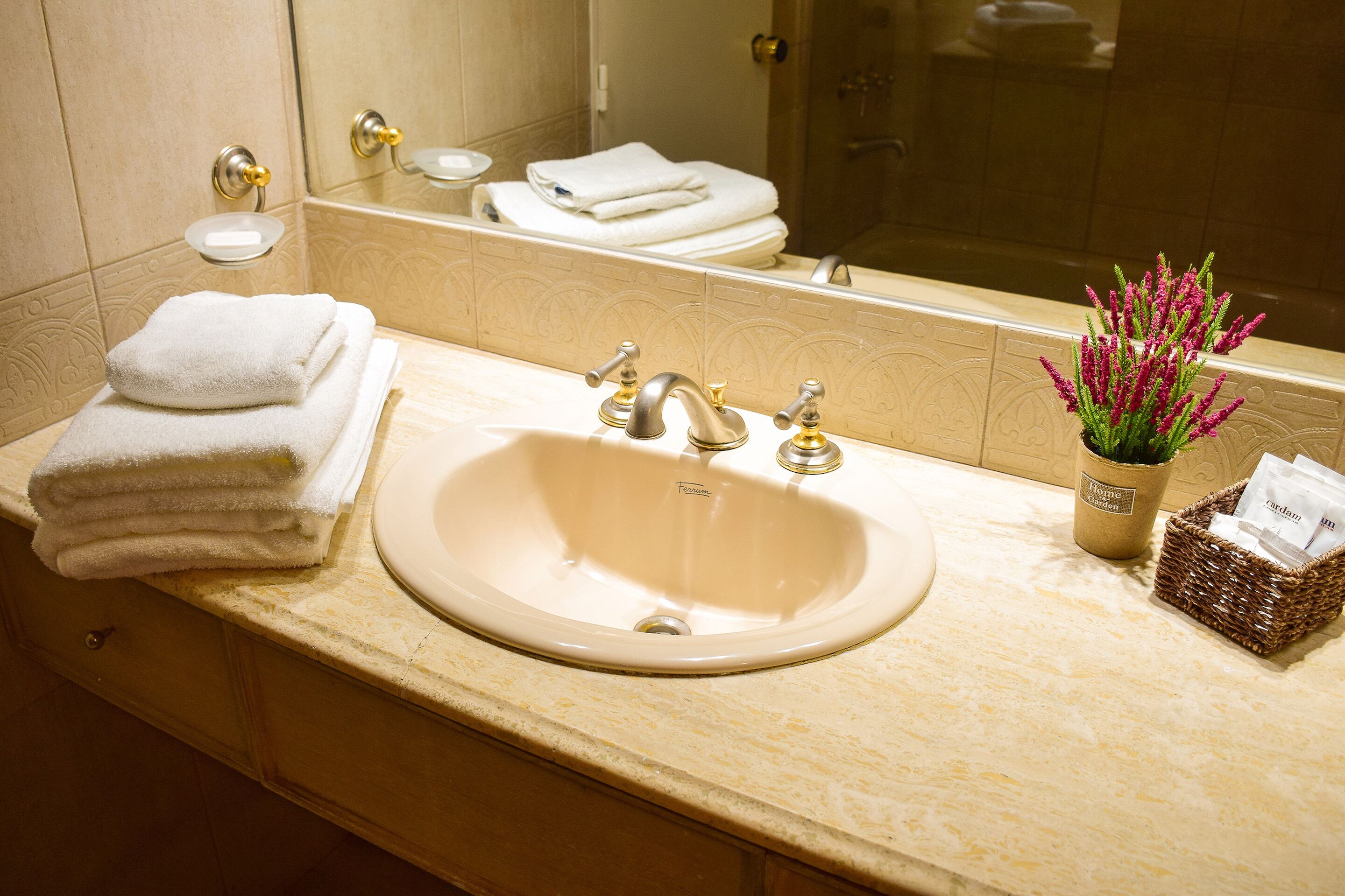 A bathroom with a sink, mirror, and towels.