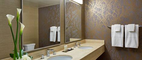 A bathroom with two sinks, a large mirror, and a towel rack.