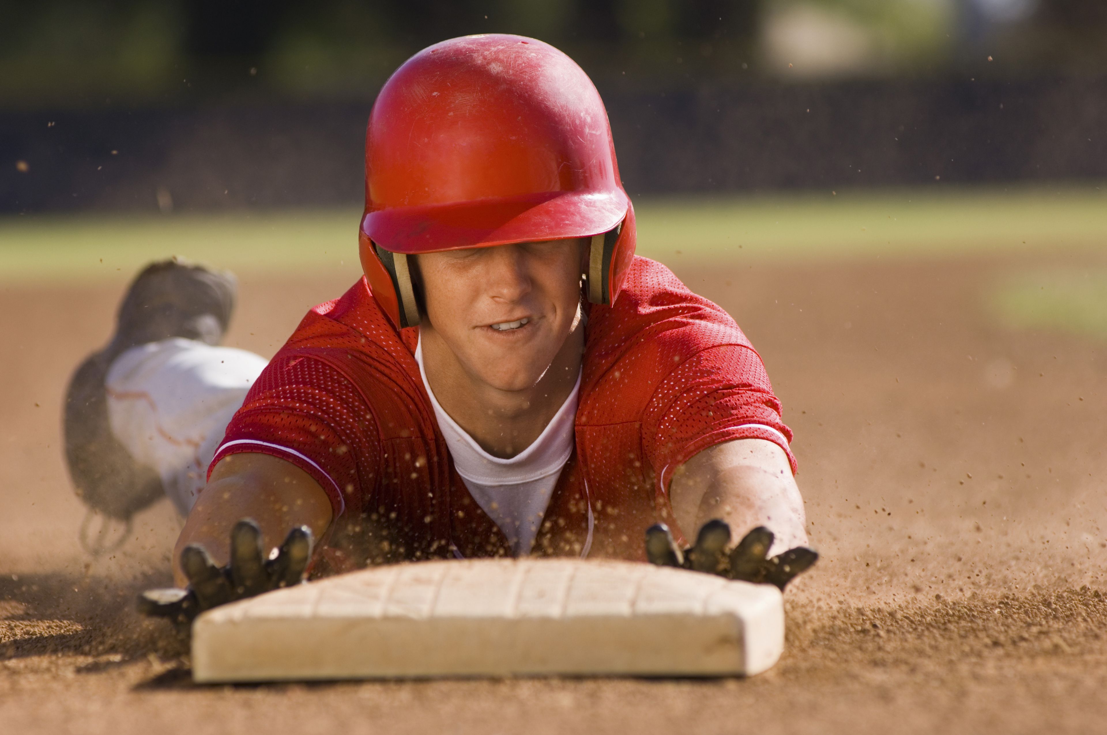 Un jugador de béisbol deslizándose hacia una base.