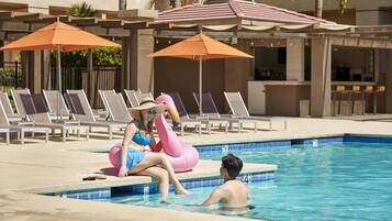 A pool area with lounge chairs and umbrellas.