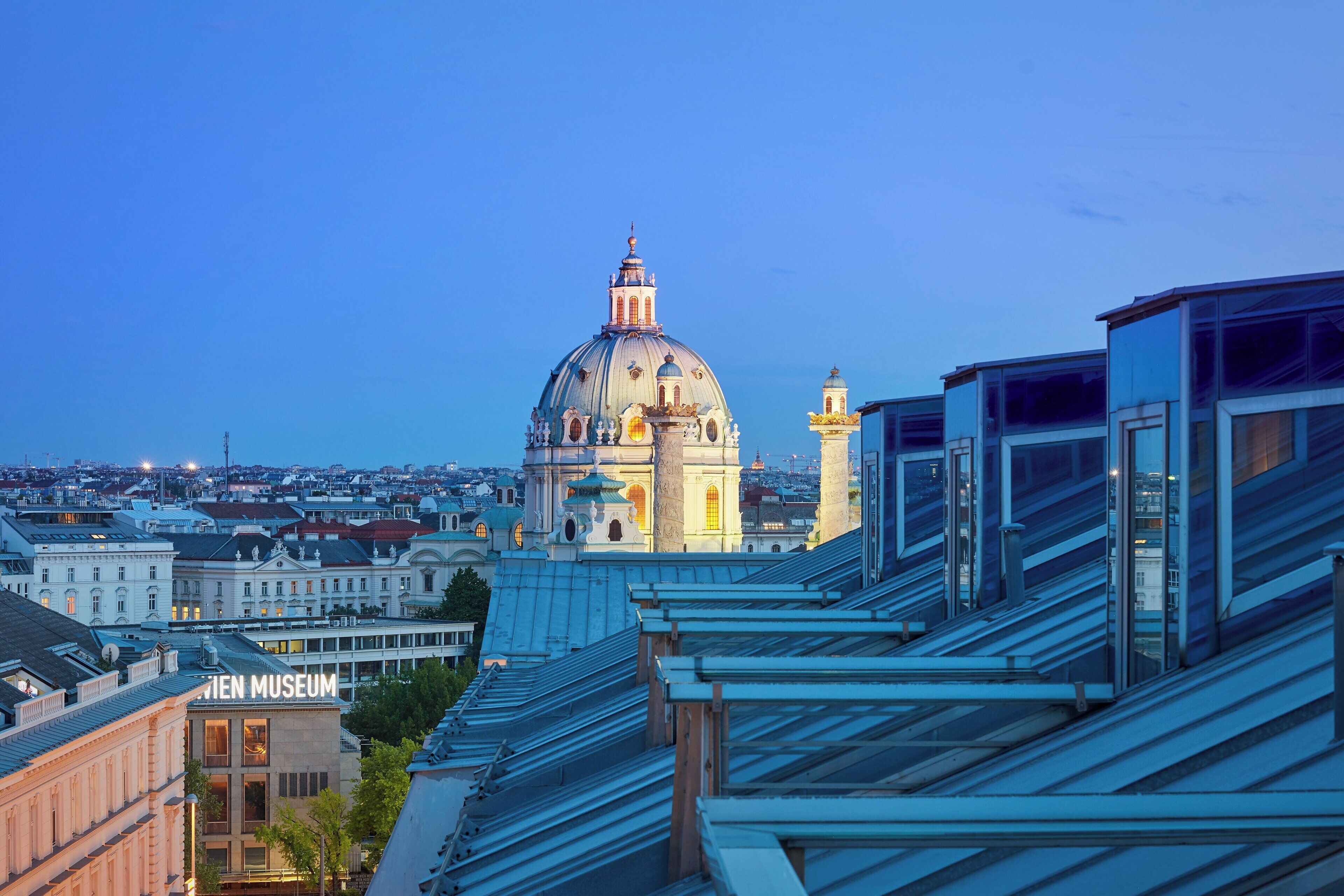 Un paisaje urbano con una cúpula destacada y un edificio que dice "Vien Museum".