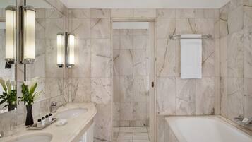 A modern bathroom with two sinks, a bathtub, and a shower.
