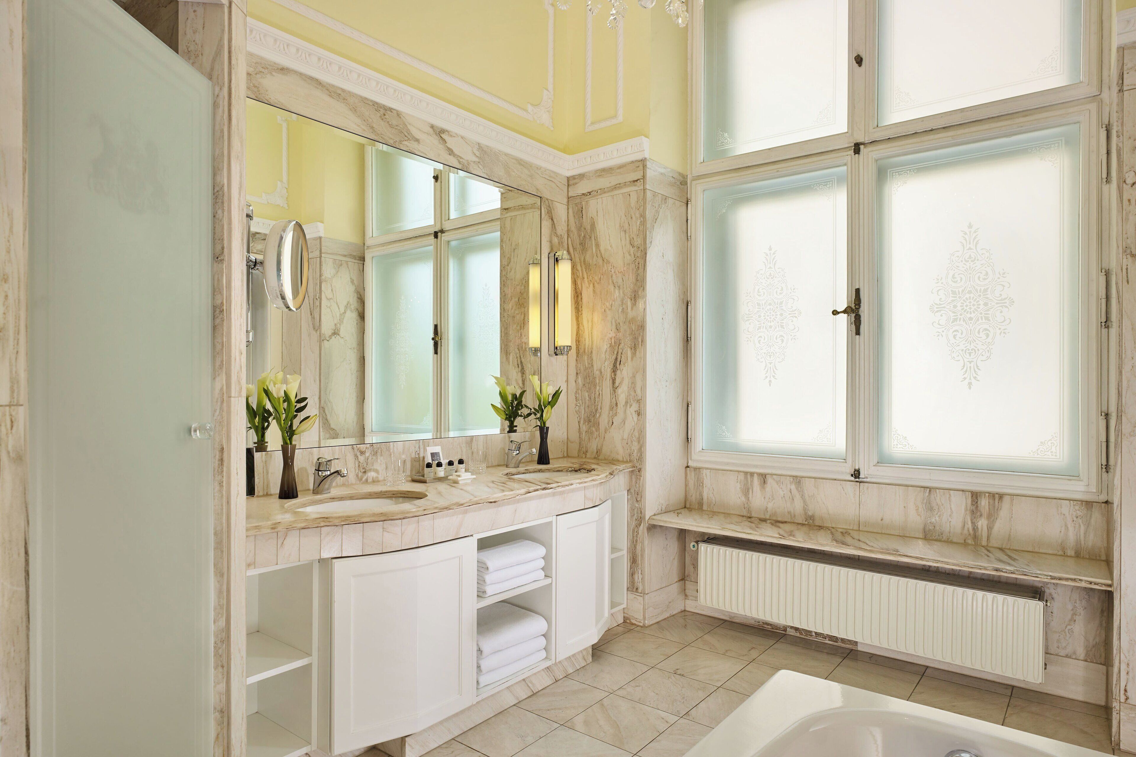 Un baño espacioso con una bañera grande, dos lavamanos y un tocador con espejo.