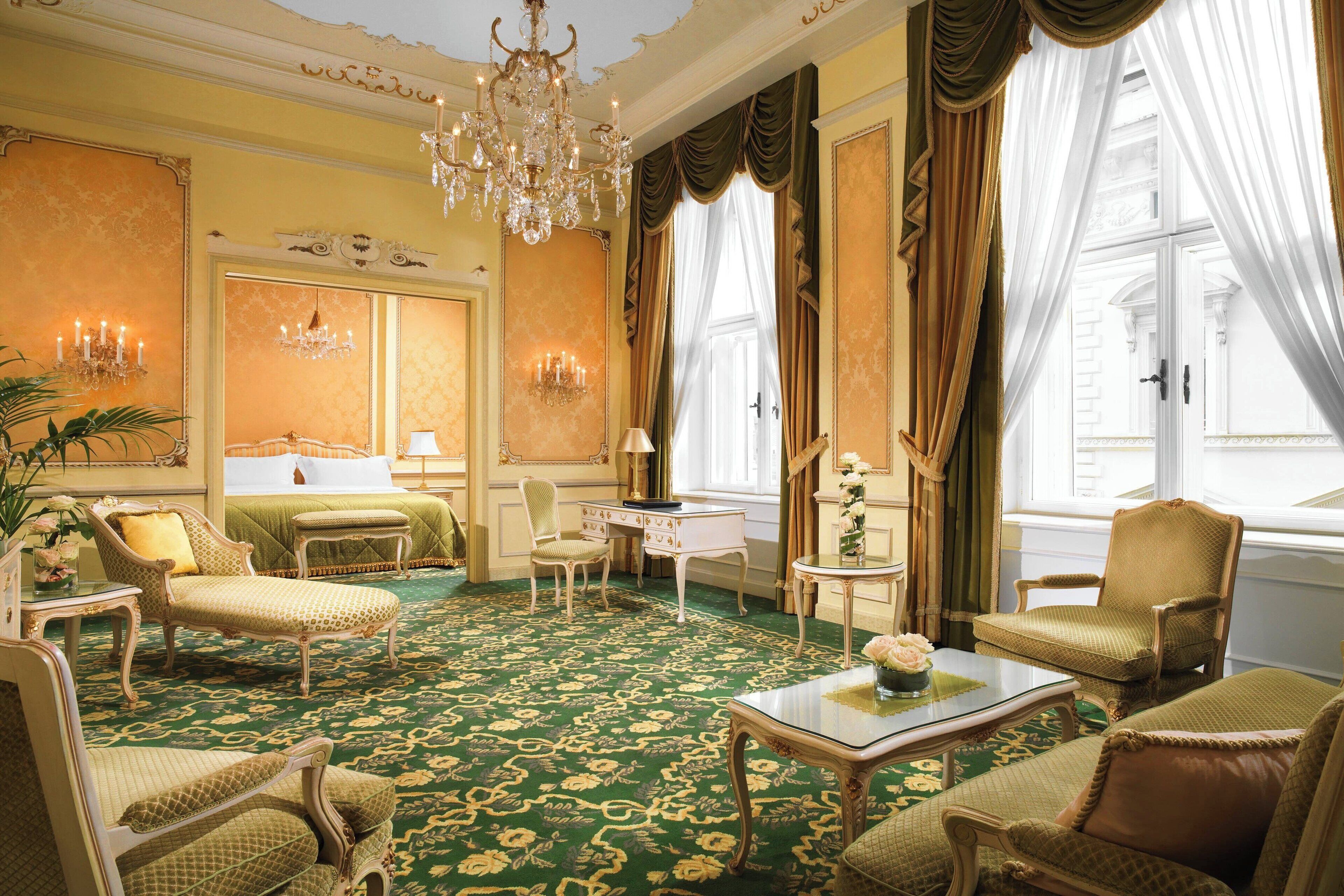 Een luxe kamer met sierlijk meubilair, een kroonluchter en een tapijt met een groen patroon.