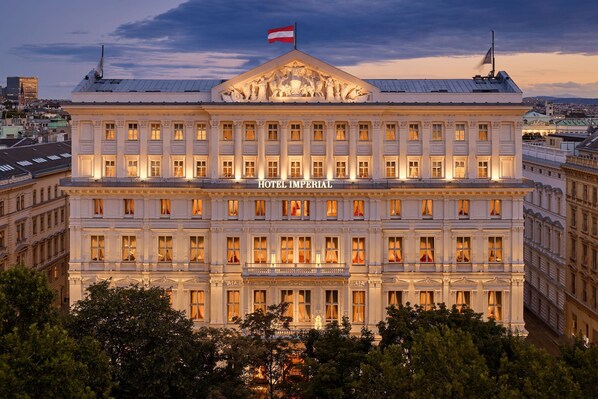 A large, historic building with a prominent flag, labeled "HOTEL IMPERIAL," featuring classical architecture and multiple windows.
