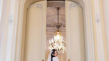 A grand hallway with ornate white walls and a large chandelier.