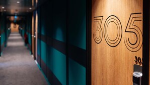A hallway with a wooden wall displaying the number '305' and a door handle. - ibis Styles Lyon Sud Vienne (Chasse-sur-Rhone)