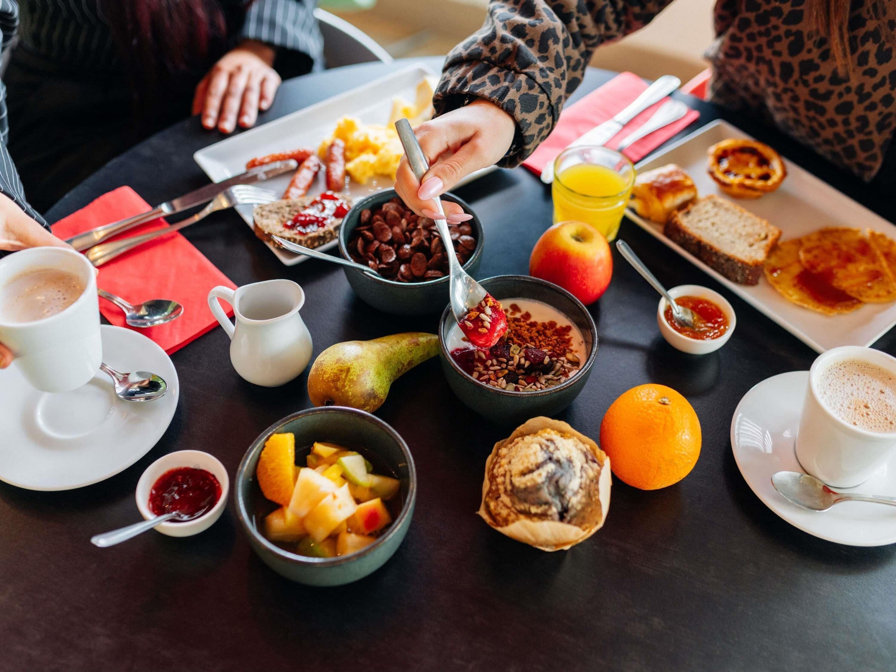 Colazione con diversi cibi e bevande su un tavolo.