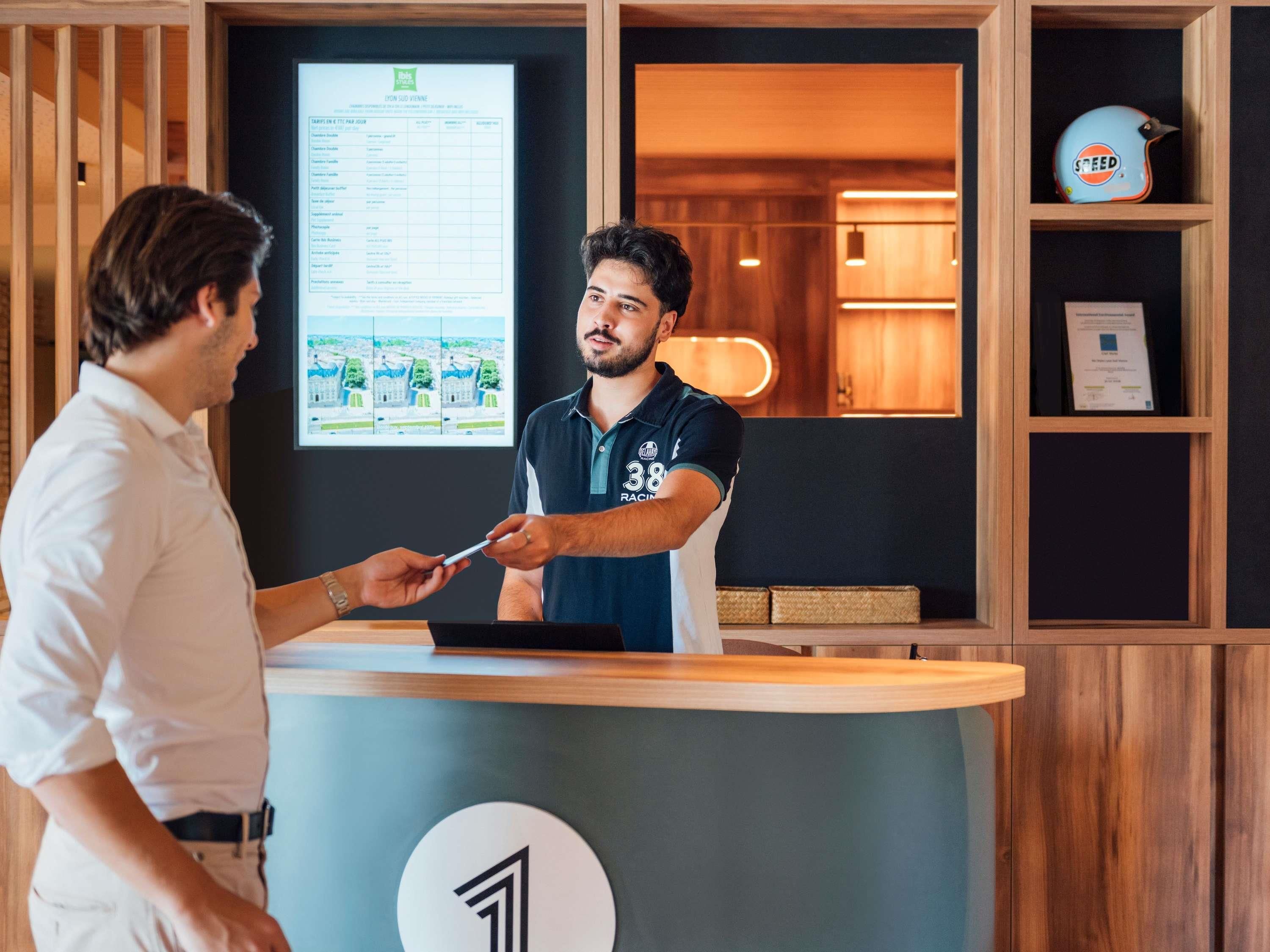 A reception desk with a digital display, a wooden reception area, and a speedo on a shelf.