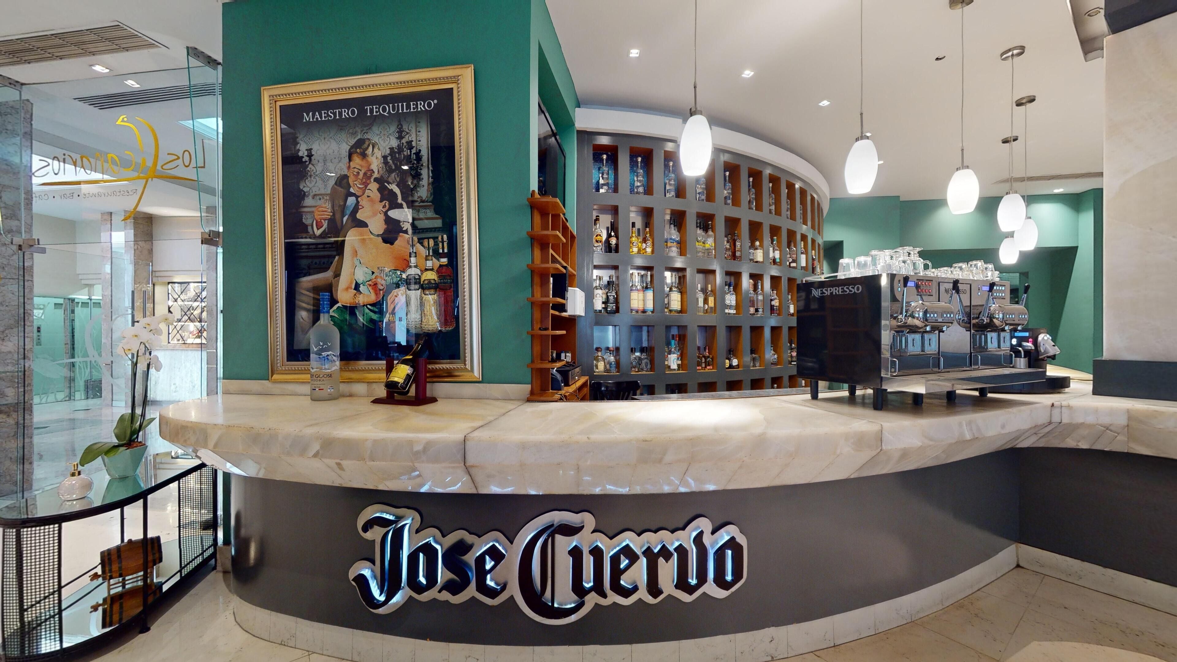 A bar area with a Nespresso machine, a liquor display, and a framed picture on the wall.
