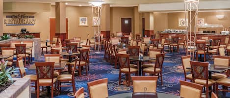 A large dining area with multiple tables and chairs, a reception desk, and a sign for a Park Place Restaurant.