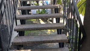 A concrete staircase with metal railings, leading to an outdoor area with greenery. - Hotel Le Rêve Pasadena (Pasadena)