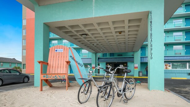A building with a sign reading "610 West Beach Blvd." and a covered area with bicycles parked.