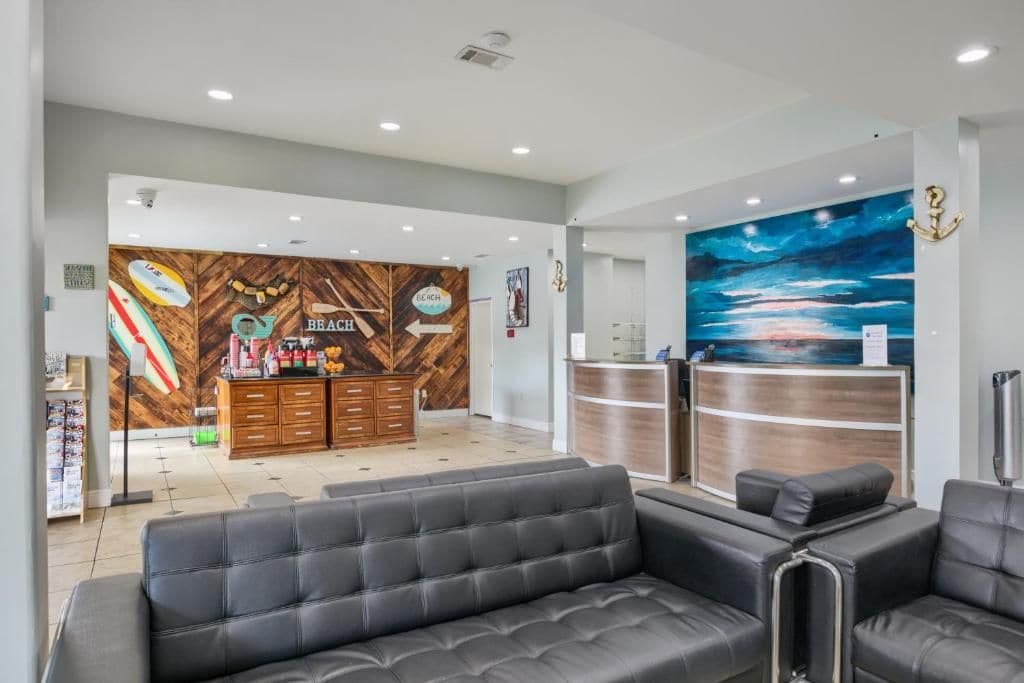 Un espace d’accueil doté d’un mur en bois, d’un comptoir de réception et d’un coin salon avec des canapés.
