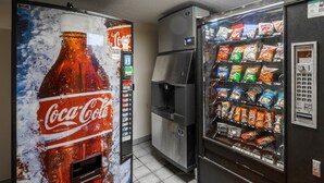 A vending machine with a Coca-Cola advertisement and a snack vending machine with various snacks. - Red Roof Inn Indianapolis South (Indianapolis)