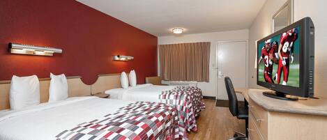 A hotel room with two beds, a television, and a desk.