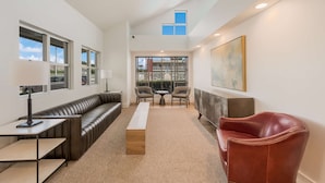 A modern lounge area with a leather sofa, a wooden bench, and two chairs.