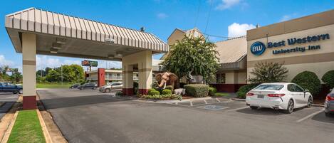 A Best Western University Inn with a gas station canopy, parking lot, and a statue of an elephant.