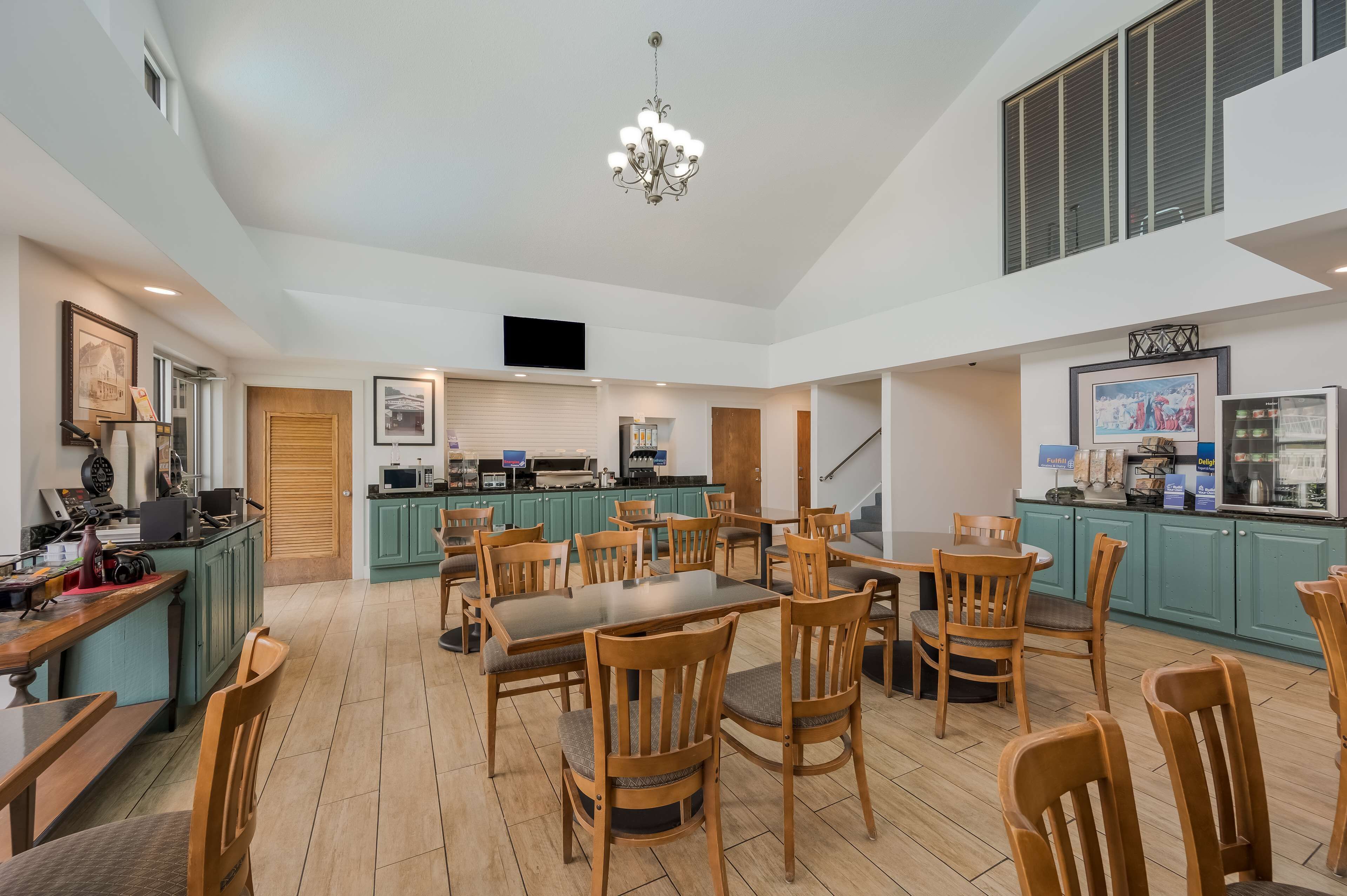 A spacious kitchen with wooden chairs, a dining table, and a chandelier.