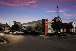 A hotel with a prominent 'BIW' sign, a parking lot, and a flagpole.