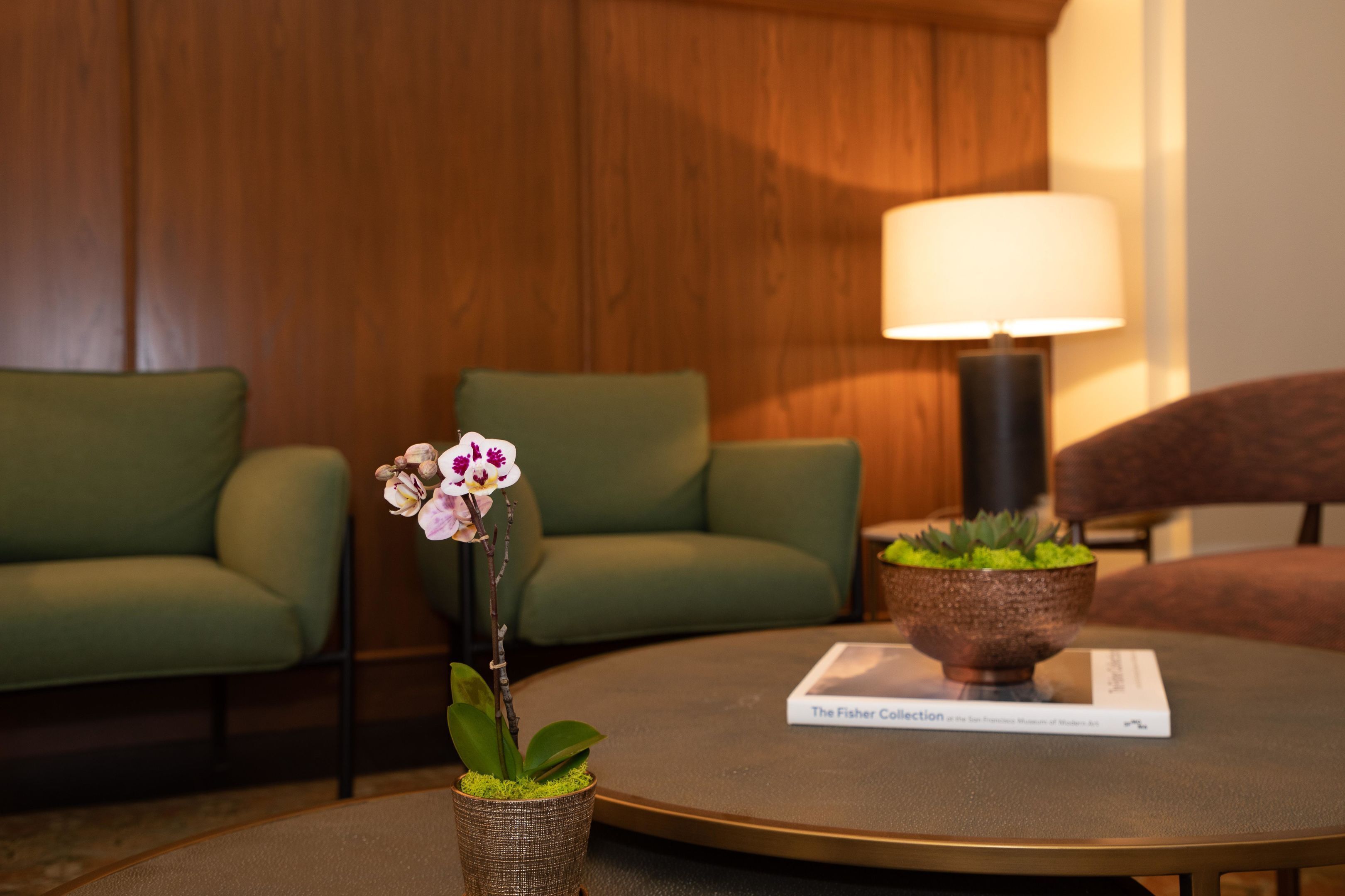 A round table with a book titled 'The Fisher Collection' and a small potted plant.