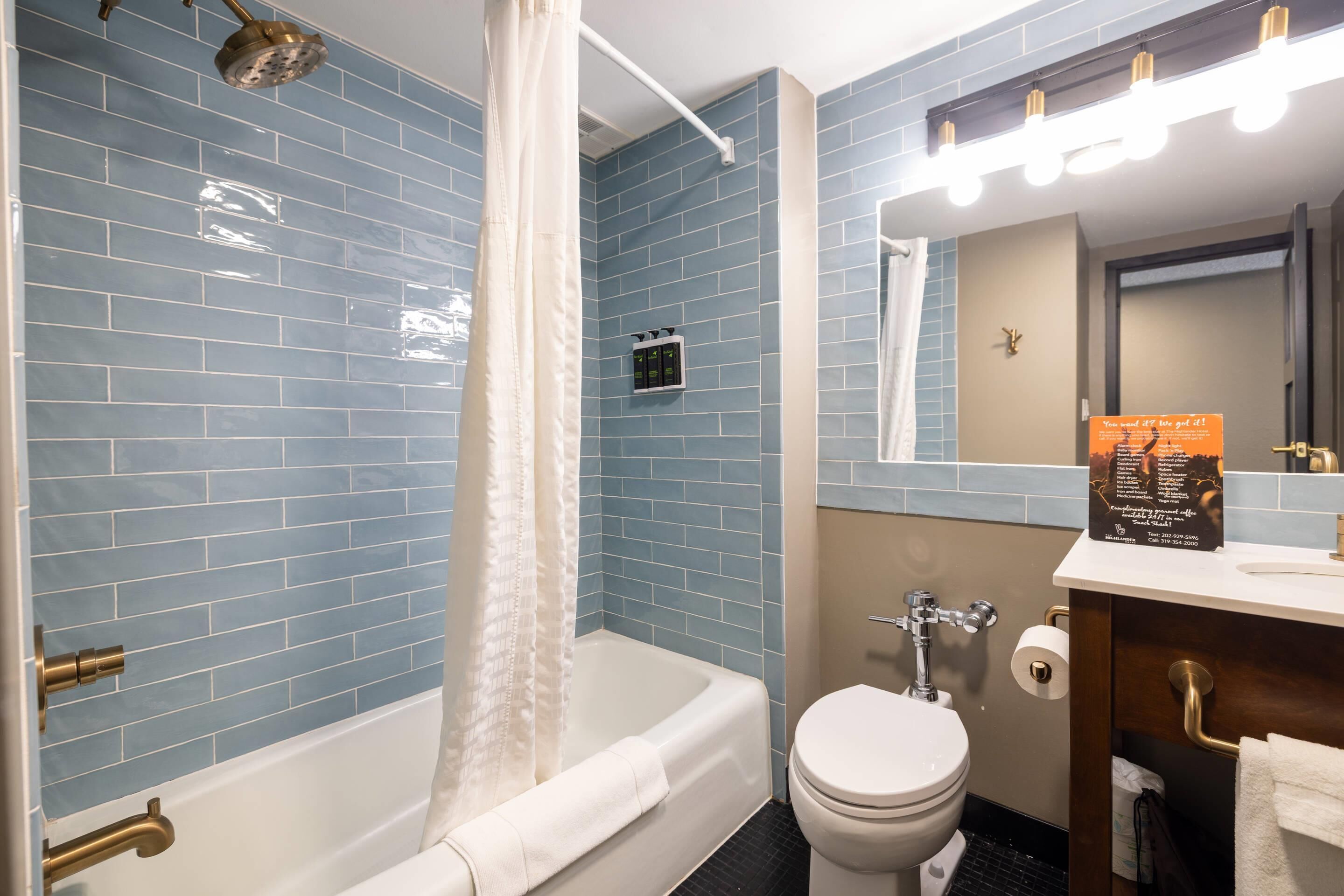 Un bagno con vasca, toilette e lavabo con specchio.