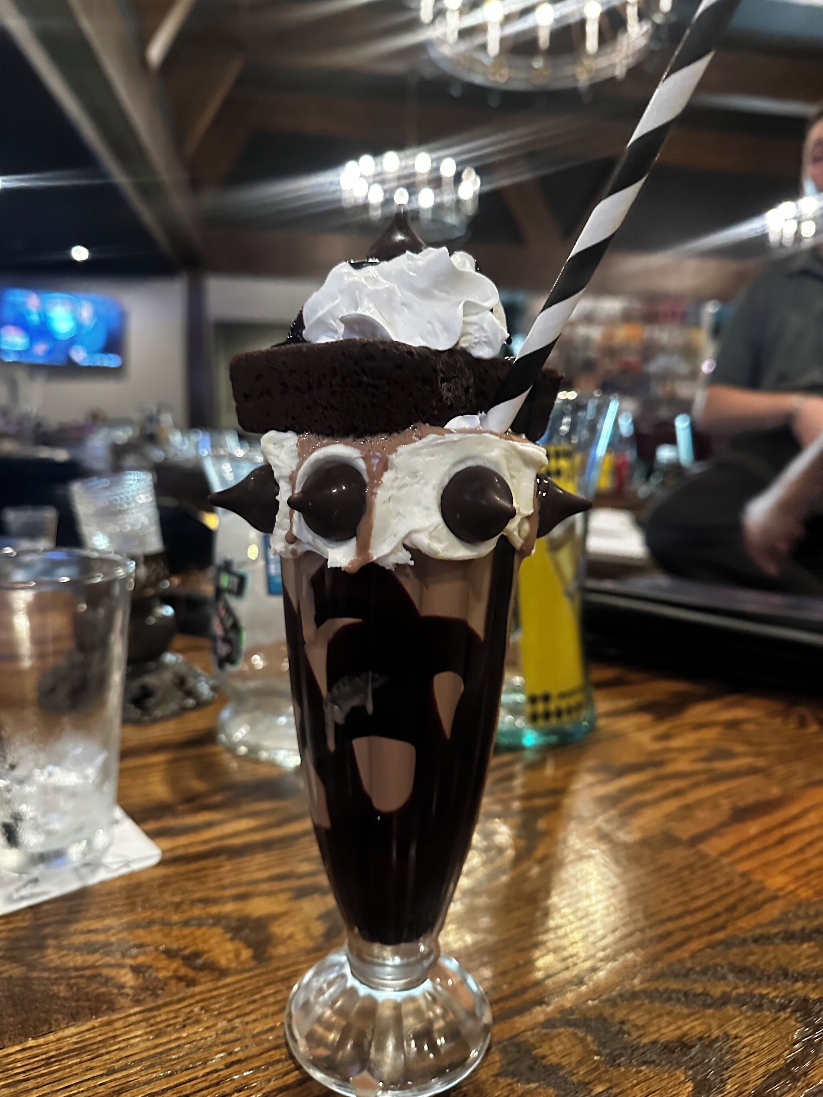A dessert with whipped cream and chocolate chips on a glass.