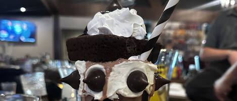 A dessert with whipped cream and chocolate chips on a glass.