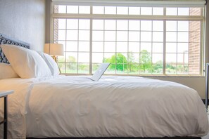 Relax in a serene space with a large bed and natural views.