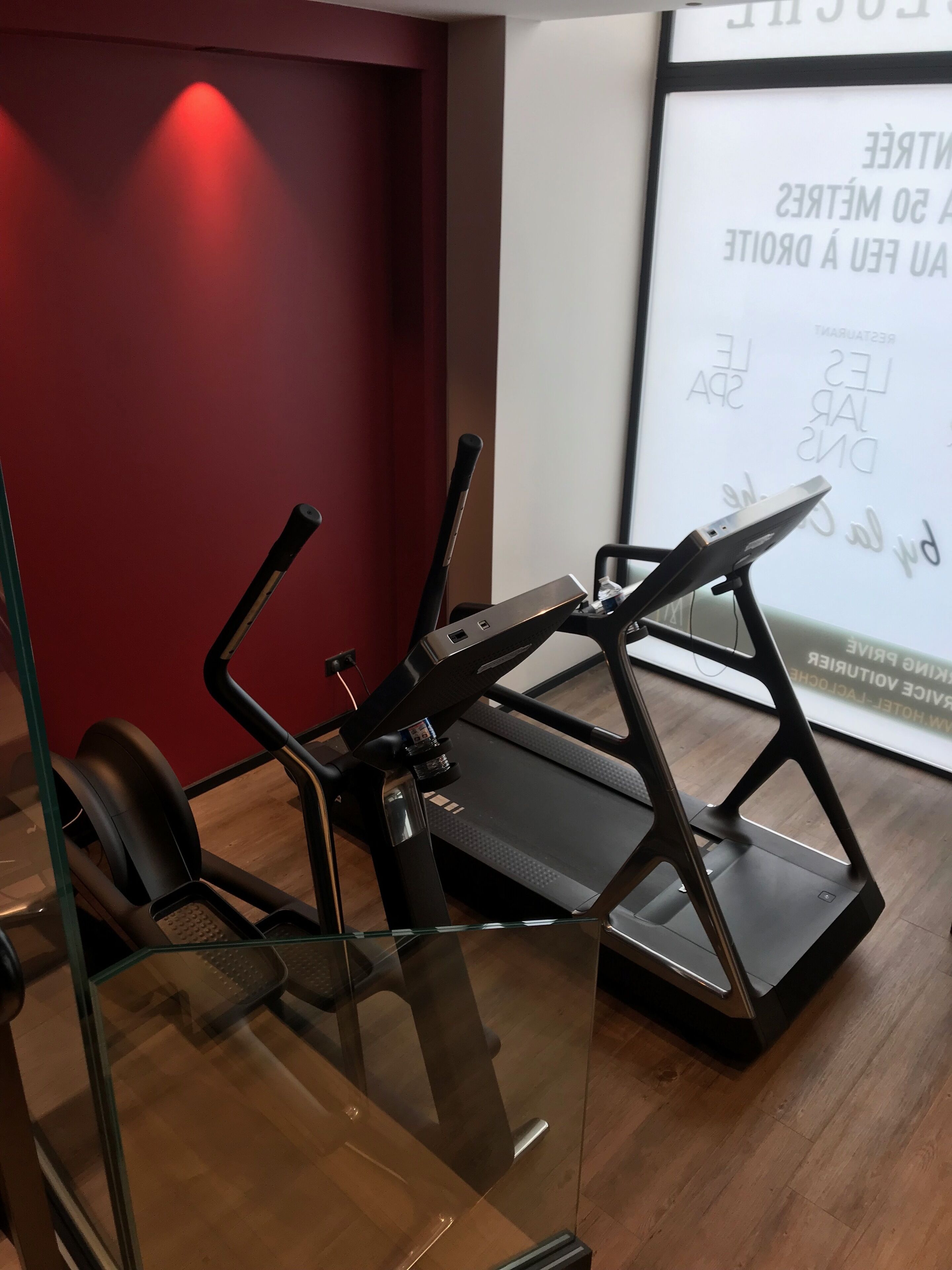 Uma academia em casa com esteira, bicicleta ergométrica e pesos.
