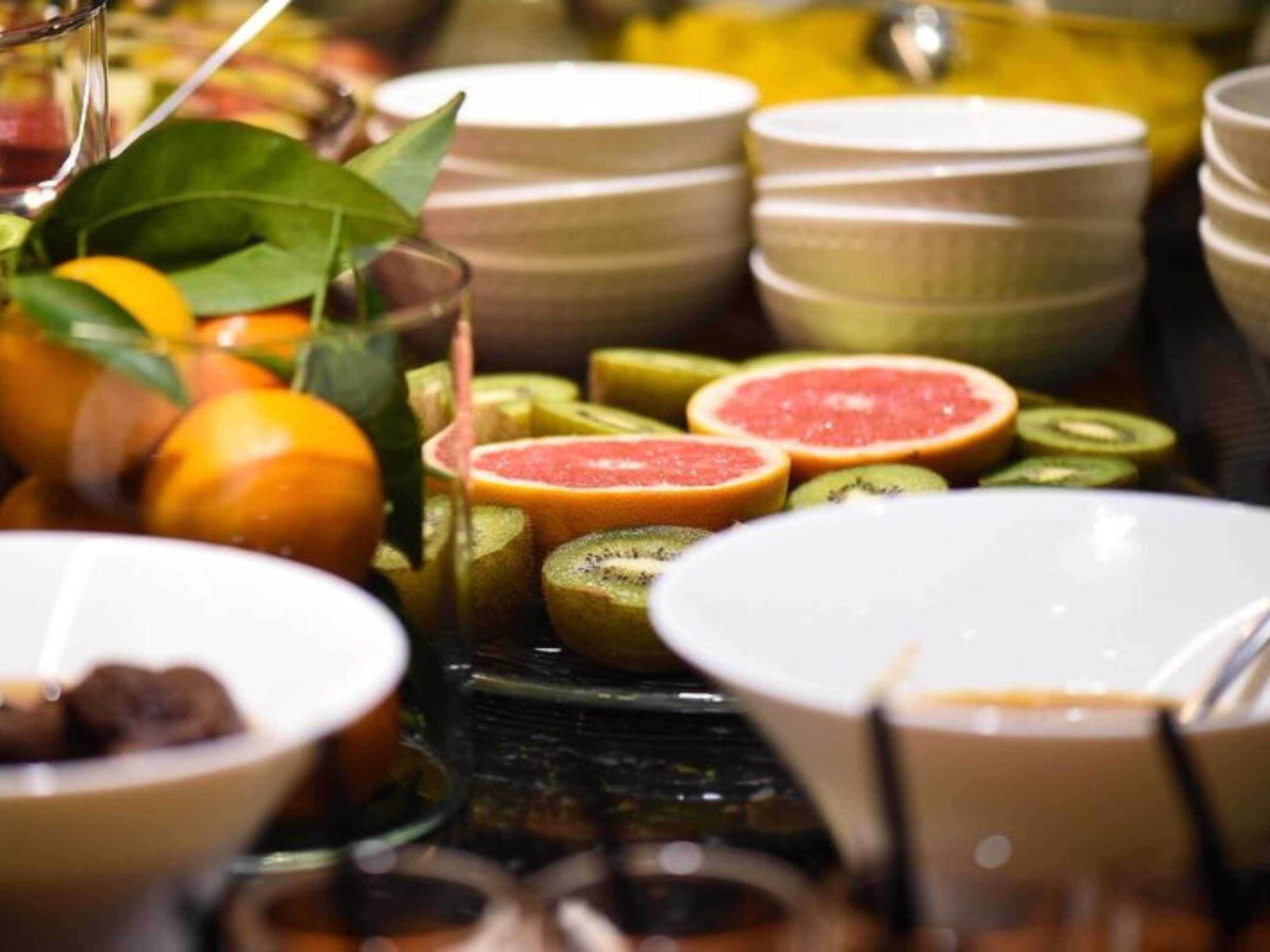 A buffet with various fruits and bowls.