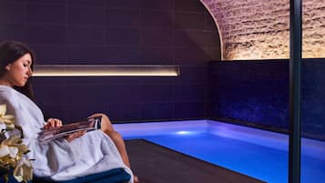 Guests can unwind in a serene spa setting with a tranquil pool area and comfortable seating.