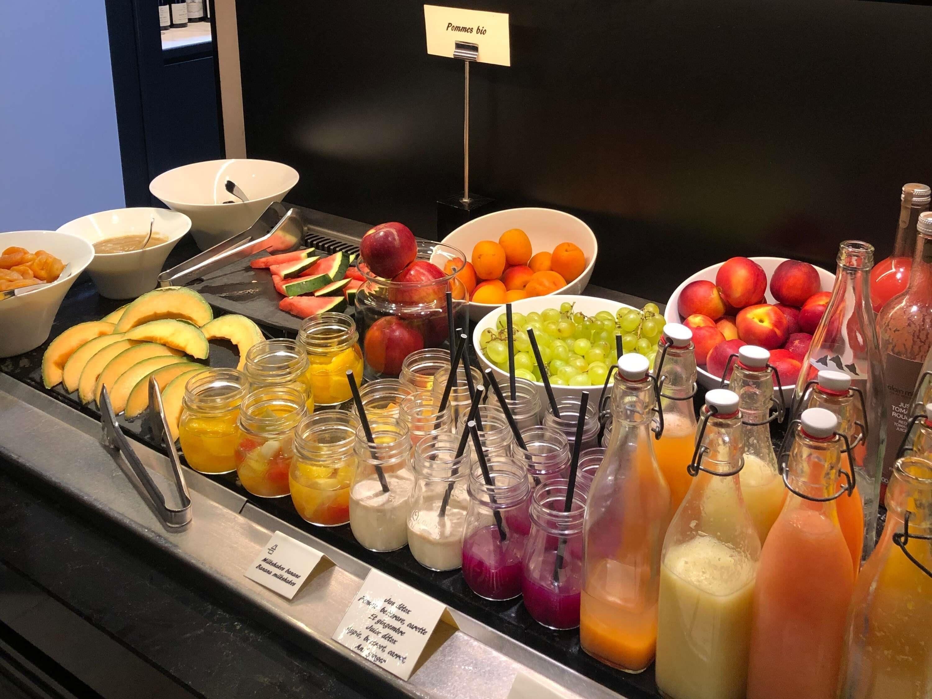 Un bufé con frutas, verduras y bebidas variadas.