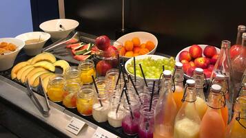 Un bufé con frutas, verduras y bebidas variadas.