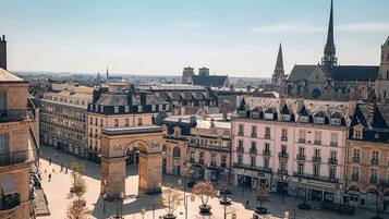 Una plaza histórica con un arco imponente, rodeada de arquitectura clásica y una catedral al fondo.