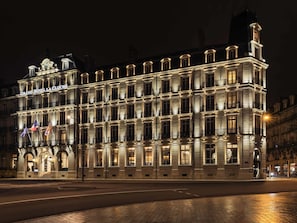 Un bĂątiment historique dotĂ© dâun imposant clocher, de nombreux balcons et dâune façade bien Ă©clairĂ©e.