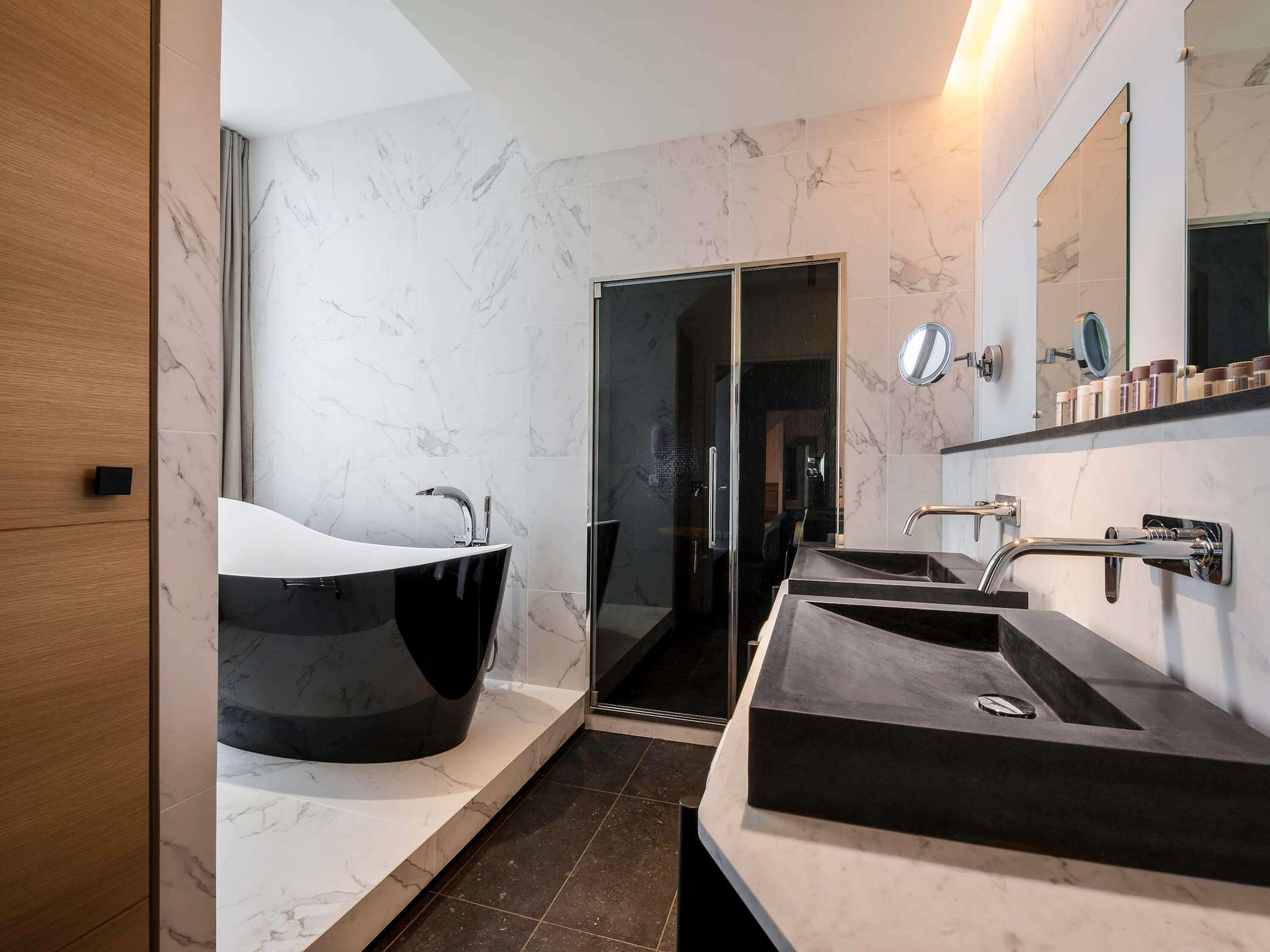 A modern bathroom with a large freestanding bathtub, a glass-enclosed shower, and a vanity with a sink.
