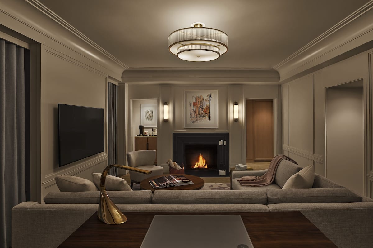 A modern living room with a fireplace, comfortable seating, and a television.