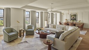 A spacious living room with a large sofa, two armchairs, a coffee table, and a dining area with a table and chairs. - The Newbury Boston (Boston)