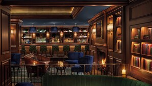A bar area with seating, a fireplace, and bookshelves. - The Newbury Boston (Boston)