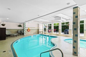 An indoor swimming pool with clear water, surrounded by lounge chairs and a tiled floor. - Best Western Maple Ridge Hotel (Maple Ridge)