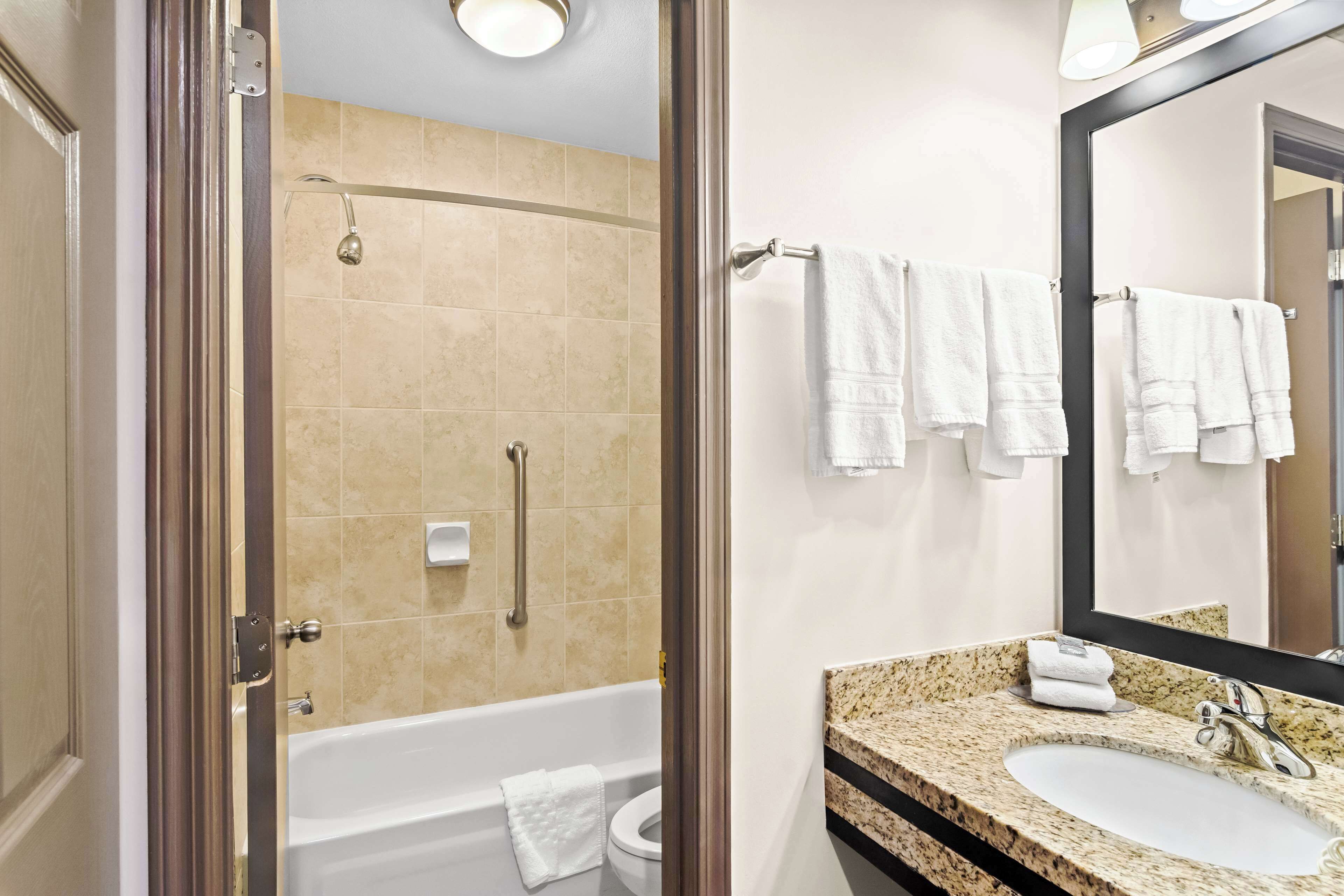 A bathroom with a bathtub, toilet, and sink.