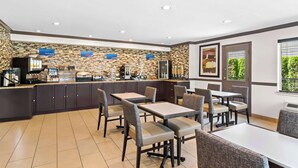 A modern kitchen area with a counter, seating area, and a view of the outdoors.