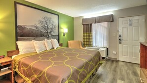 A hotel room with a large bed, a chair, a desk, and a window with curtains. - Super 8 by Wyndham Knoxville West/Farragut (Knoxville)
