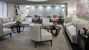 A modern living room with a sofa, armchairs, a coffee table, and a dining area. - Capitol Hill Hotel (Washington)