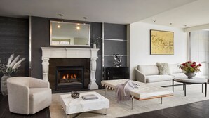 A modern living room with a fireplace, a sofa, a coffee table, and a large window.