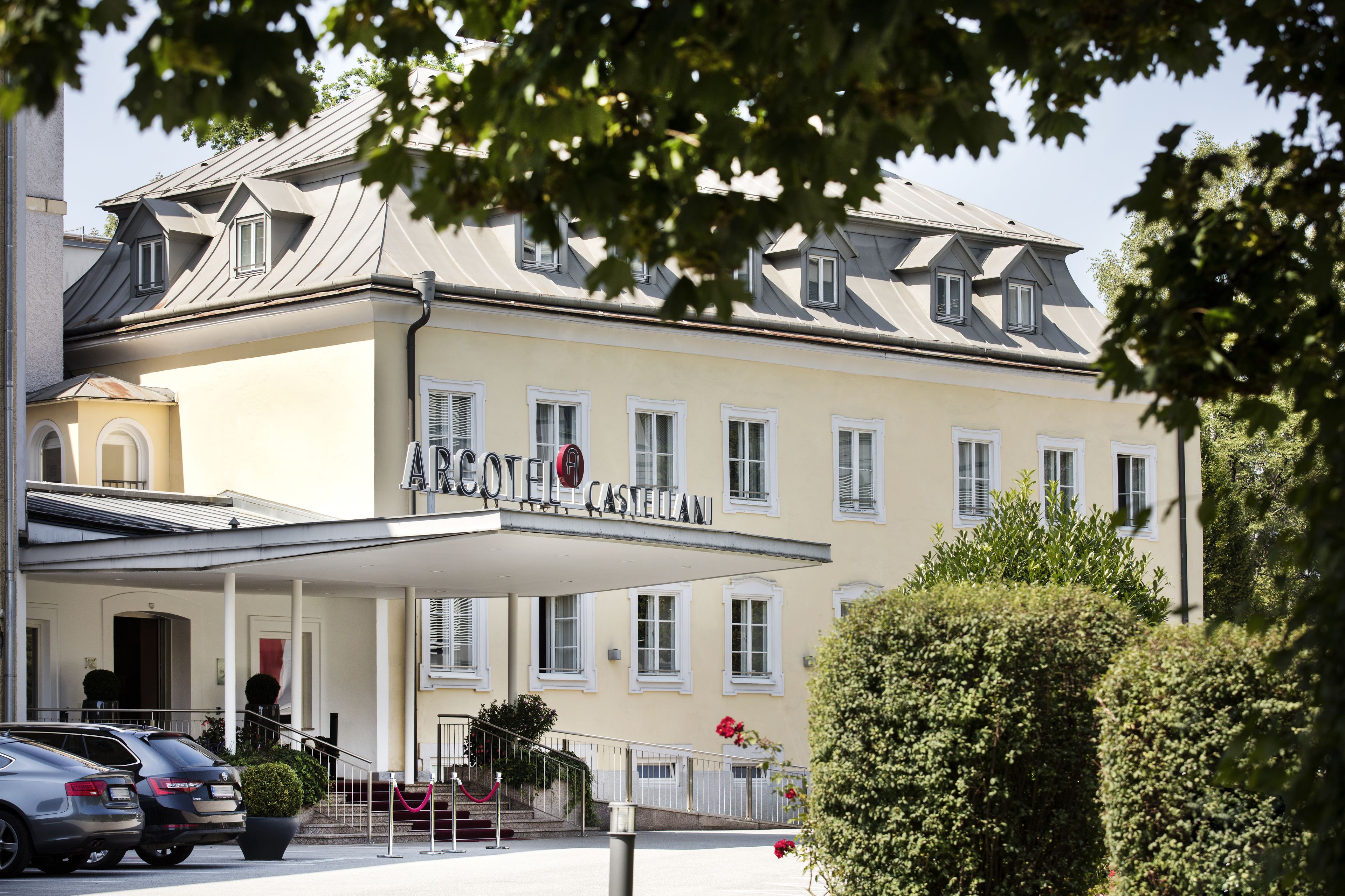 A hotel with a covered entrance, multiple windows, and a sign reading "ARCOFELLE CASTELLIANI".