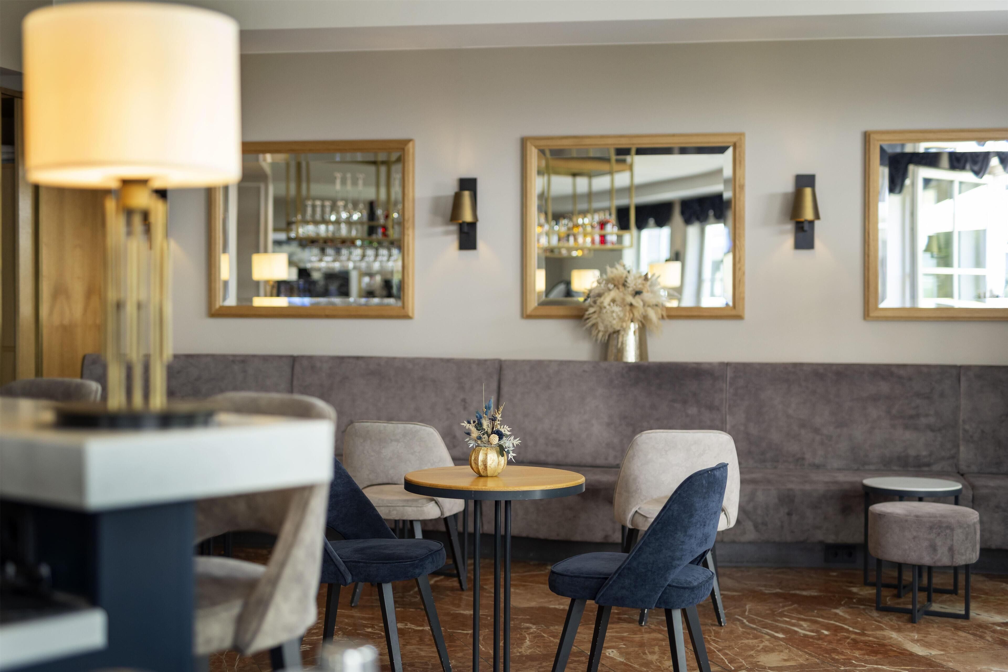 Un intérieur moderne avec une table ronde, deux chaises, un canapé et une petite table ronde.